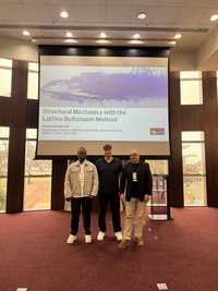 Three men standing in front of a presentation screen about Structural Mechanics at the DSDF conference 2026.